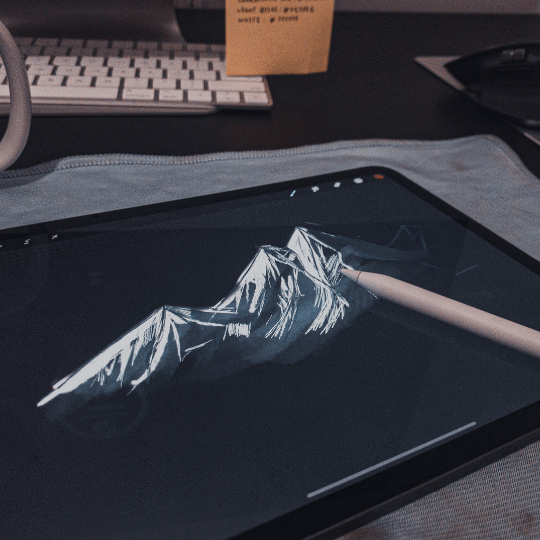 A technical staff member uses a tablet to draw a digital mountain