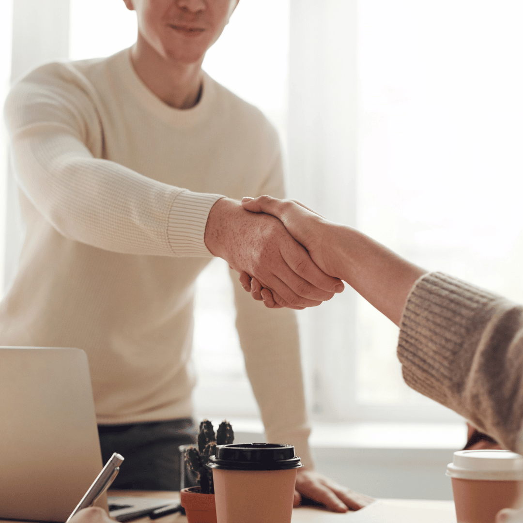 Two people shaking hands at a job interview.
