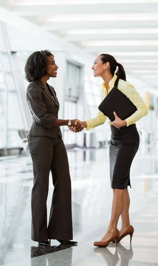 HR and Talent Acquisition Search Firm at Scion Staffing. Two women shaking hands at an HR job interview.