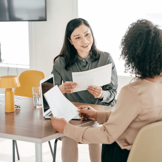 Major Hiring Pain Points of 2022 - two diverse women participating in a job interview with resumes in hand