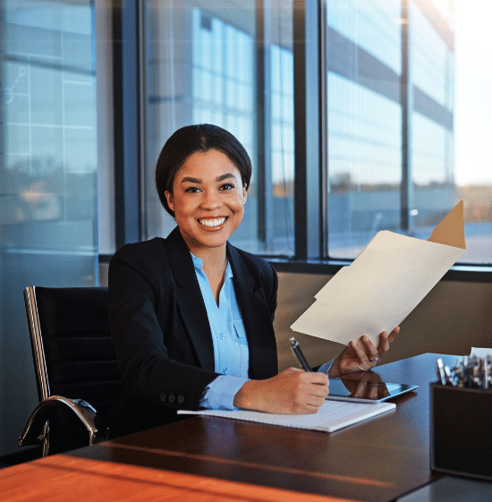 An attorney is seen smiling sitting a desk representing National Legal Recruiting