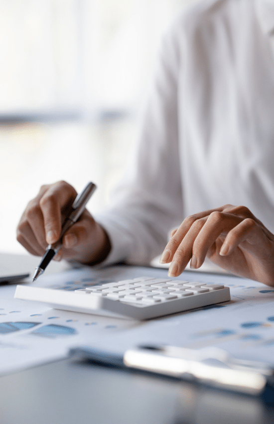 National Temporary Accounting Staffing - image of female temporary accounting employee typing on calculator and looking over graphs for project